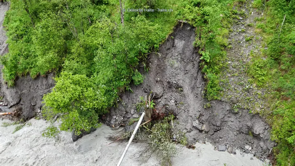 Vue par drone d’une conduite exposée sur une berge ravinée dans la région d’Évolène